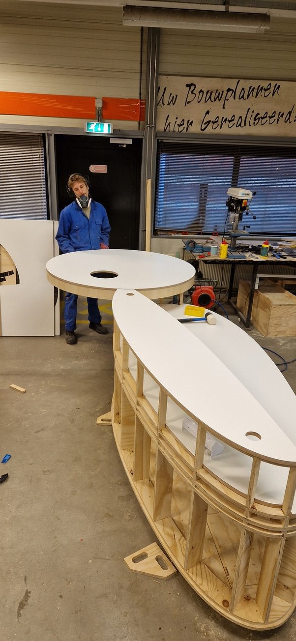 Craftsperson building a curved wooden table in the workshop